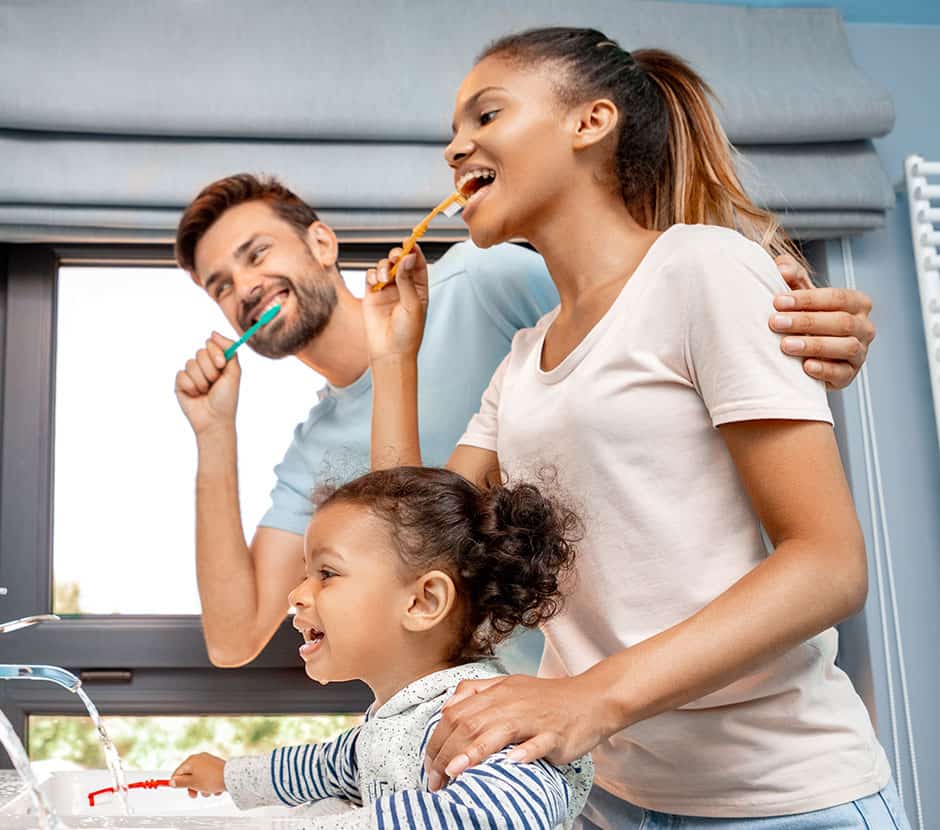 Family brushing teeth together in bathroom