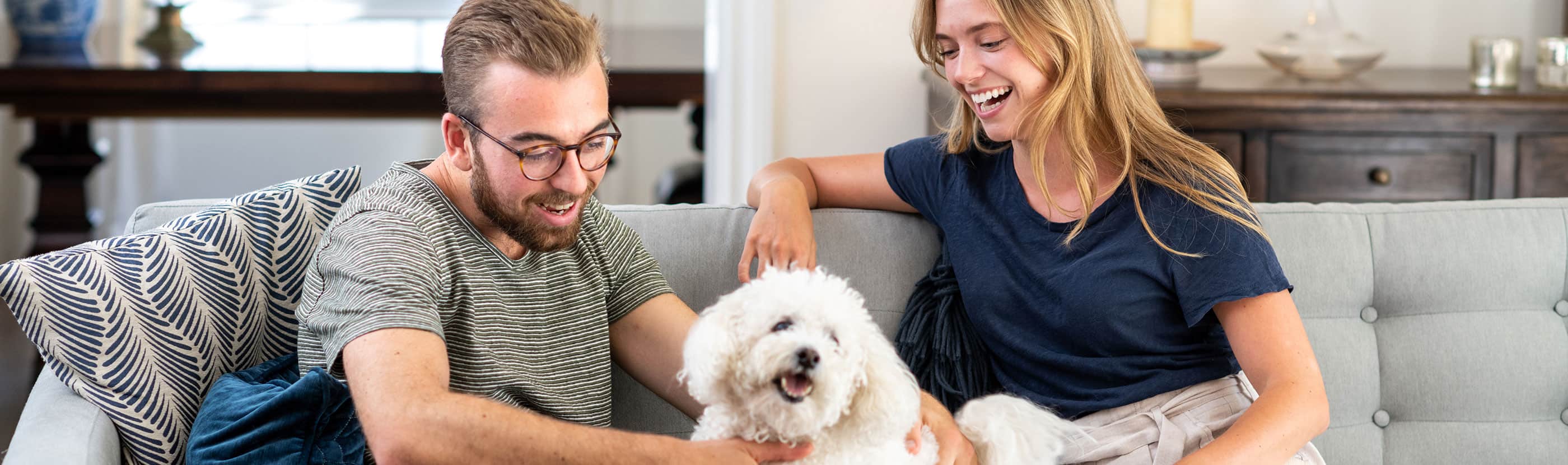 Young couple sitting on a couch with a dog