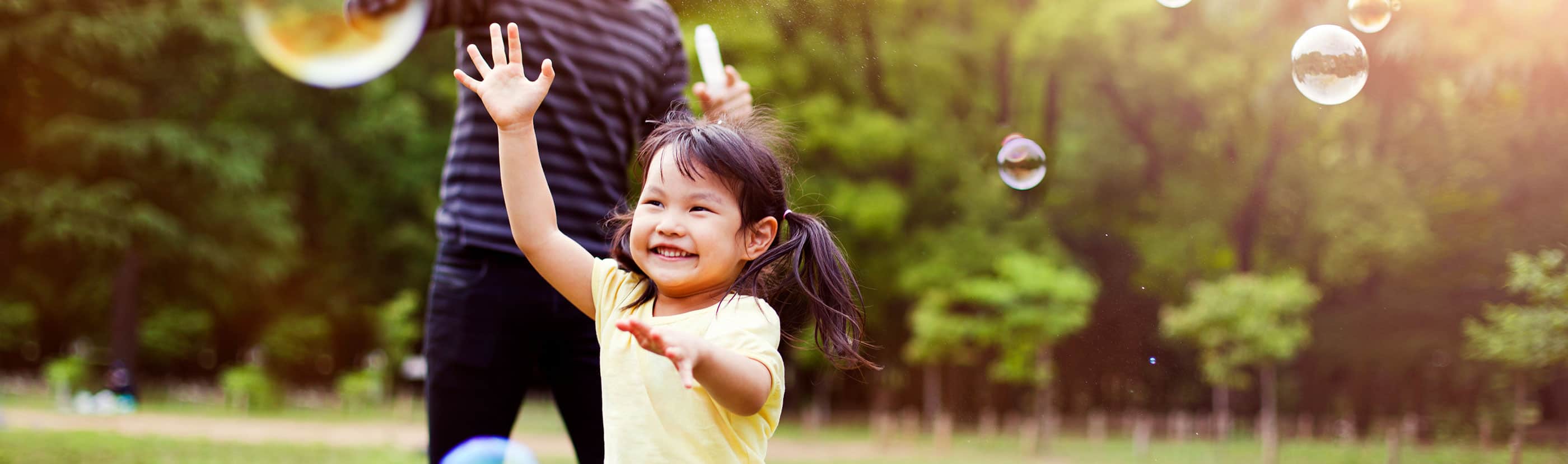 Little girl chasing bubbles