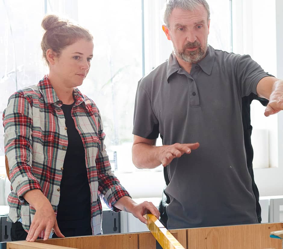 Woman and man with level and unfinished kitchen island