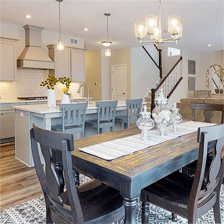 Interior view of a dining room with a kitchen island in the background