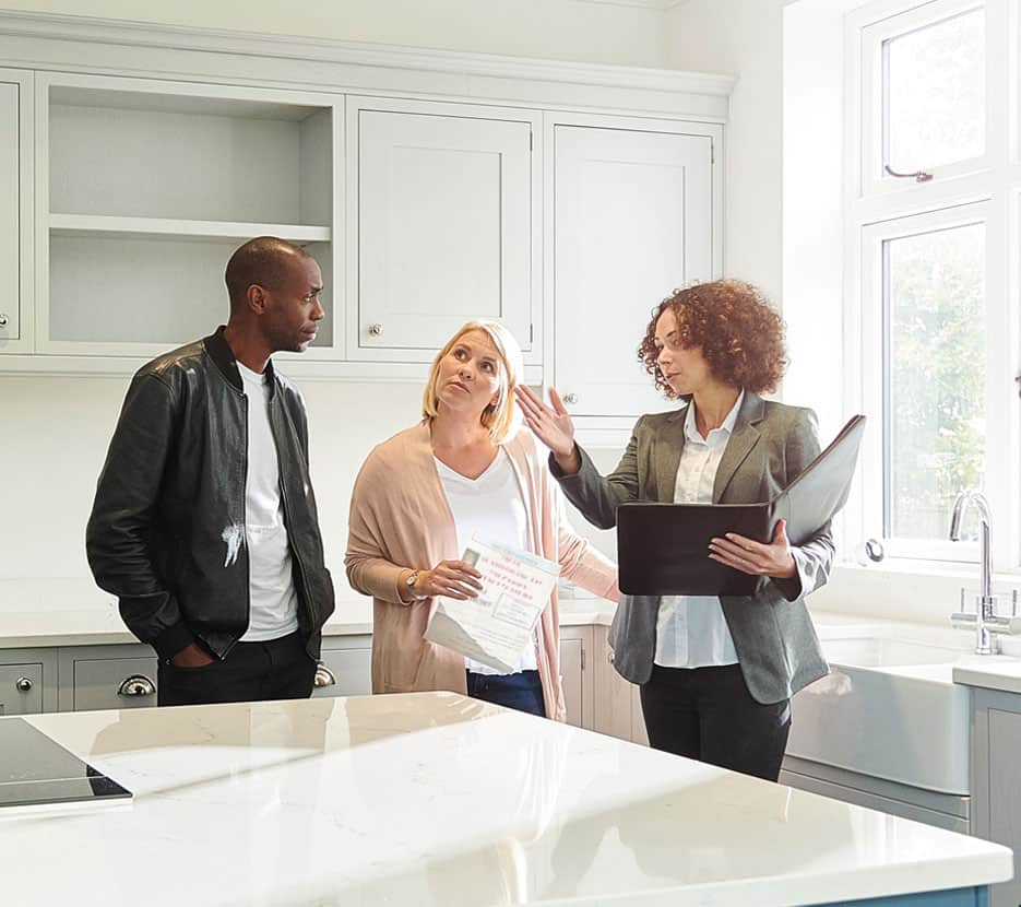 A couple tour a kitchen with a sales agent