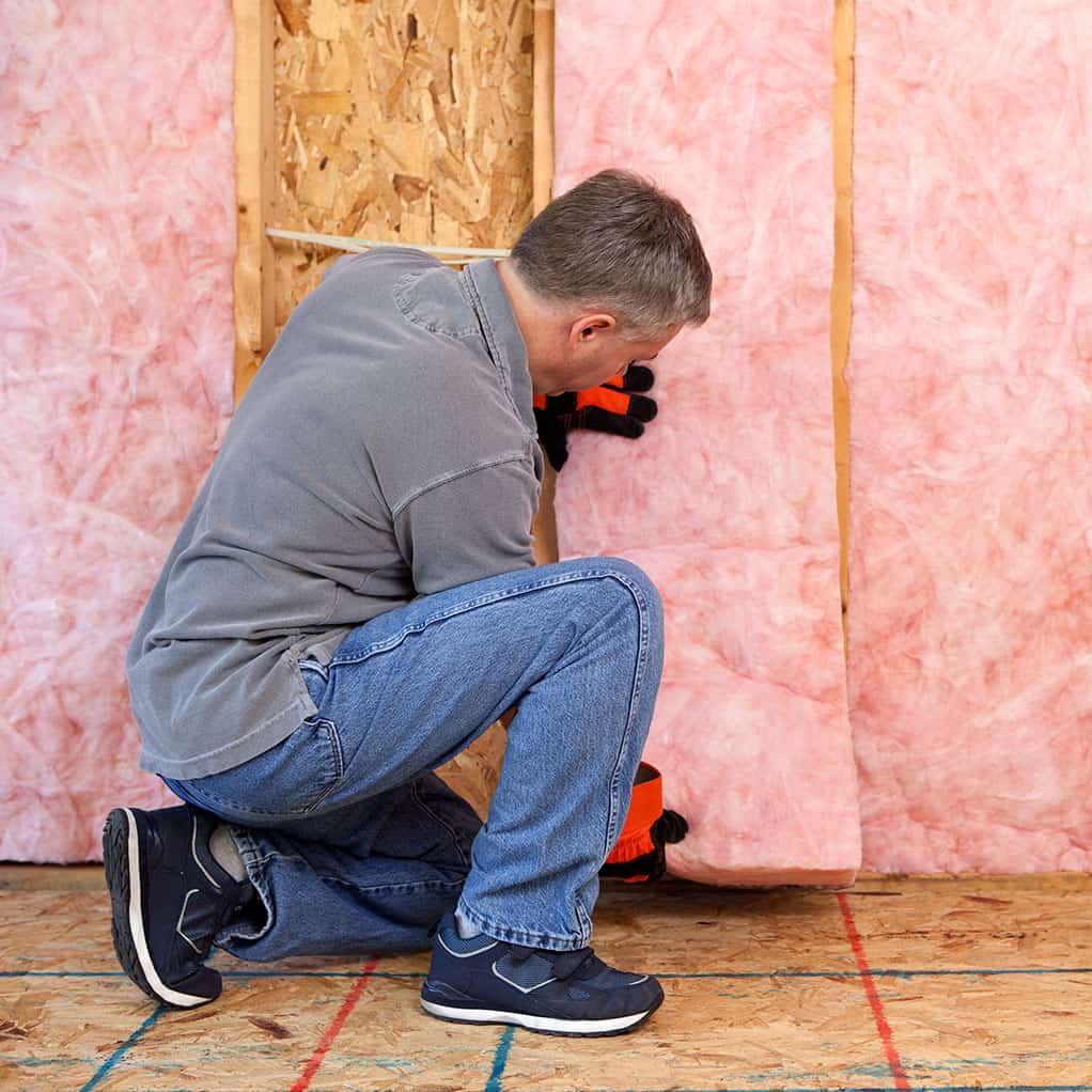 Man installing batt insulation