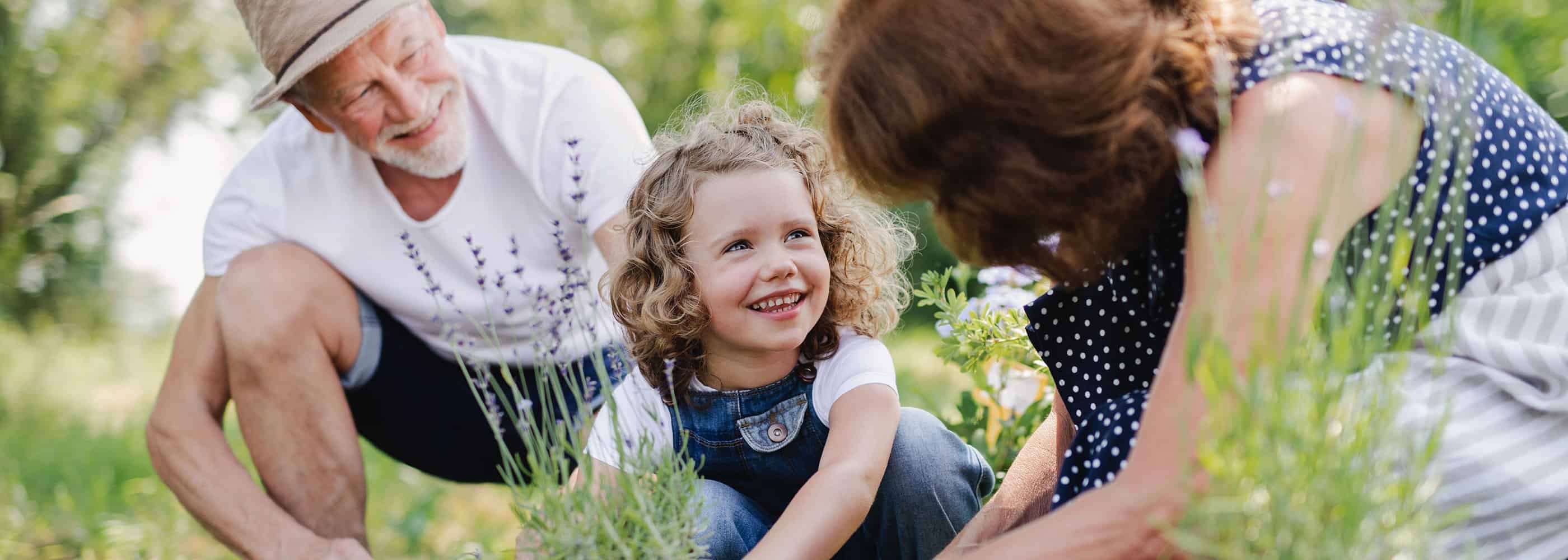 Grandparents planting flowers with their grandkid