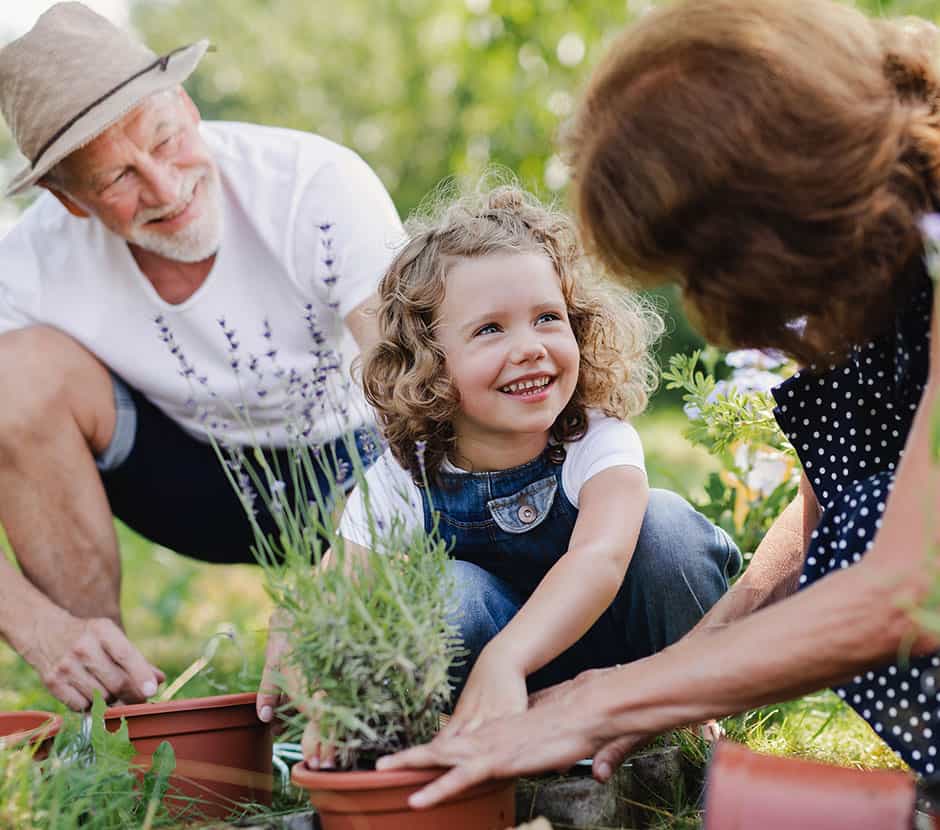 Grandparents planting flowers with their grandkid