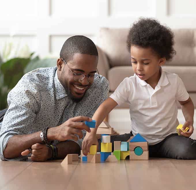 Dad playing with blocks on the floor with son