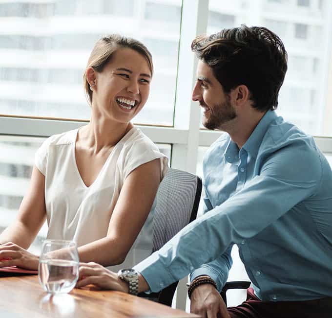 A couple smiling at a conference table