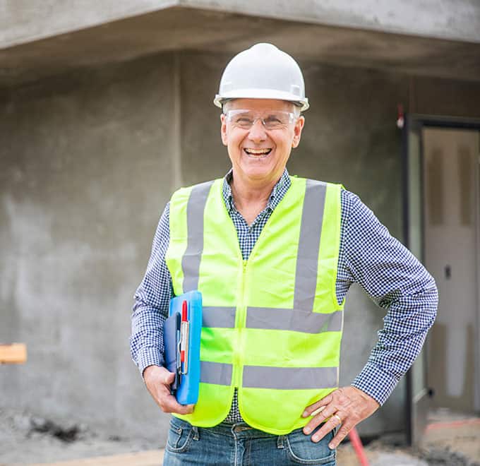 A smiling warranty manager in a hard hat